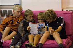 Four students reading on cushions 